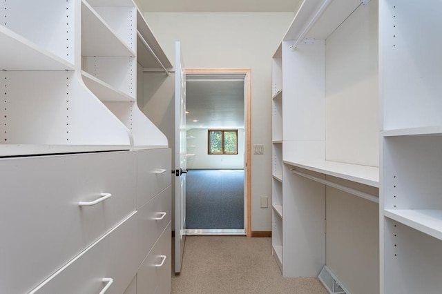 spacious closet with visible vents and light colored carpet