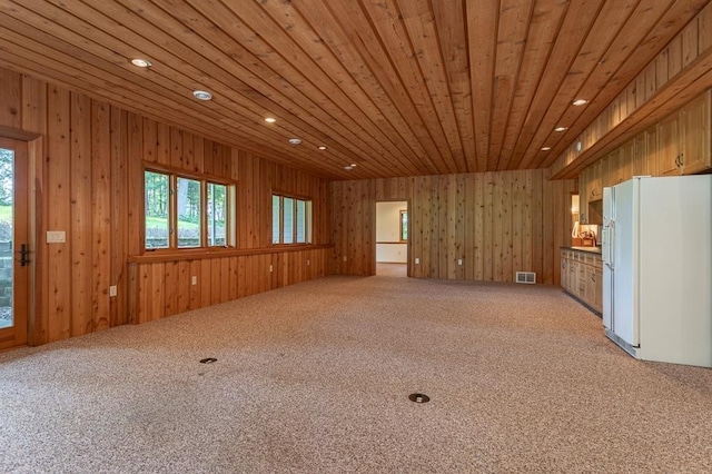 interior space featuring light carpet, wood ceiling, visible vents, and a wealth of natural light