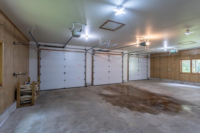 garage with a garage door opener and wood walls