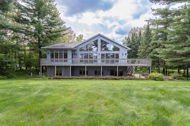 rear view of house with a deck, a yard, and stairs