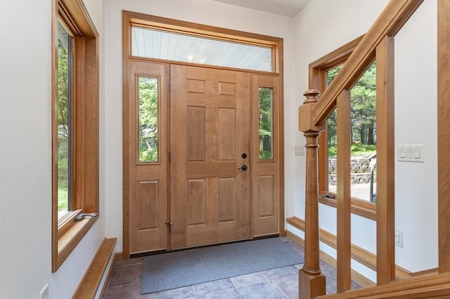 tiled foyer featuring baseboards and a wealth of natural light