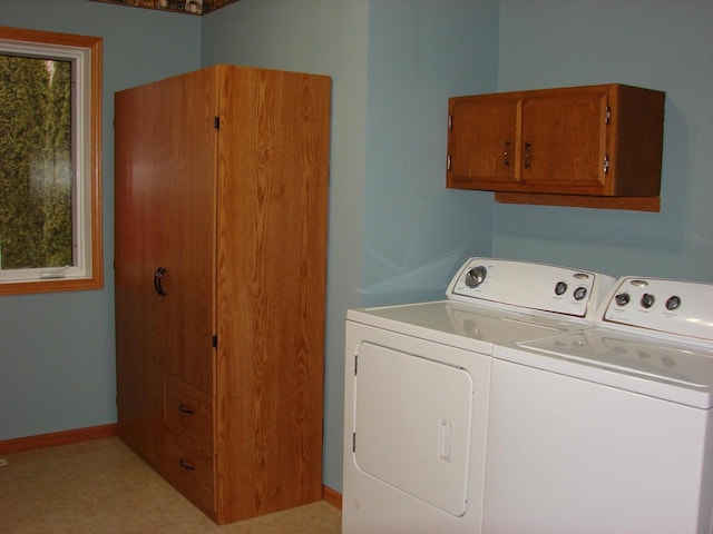 washroom with cabinet space, washing machine and dryer, baseboards, and light floors