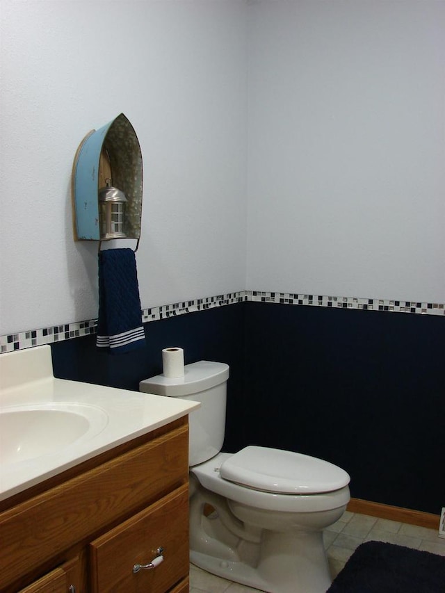 bathroom featuring tile patterned flooring, vanity, and toilet