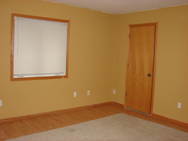 empty room with baseboards and wood finished floors