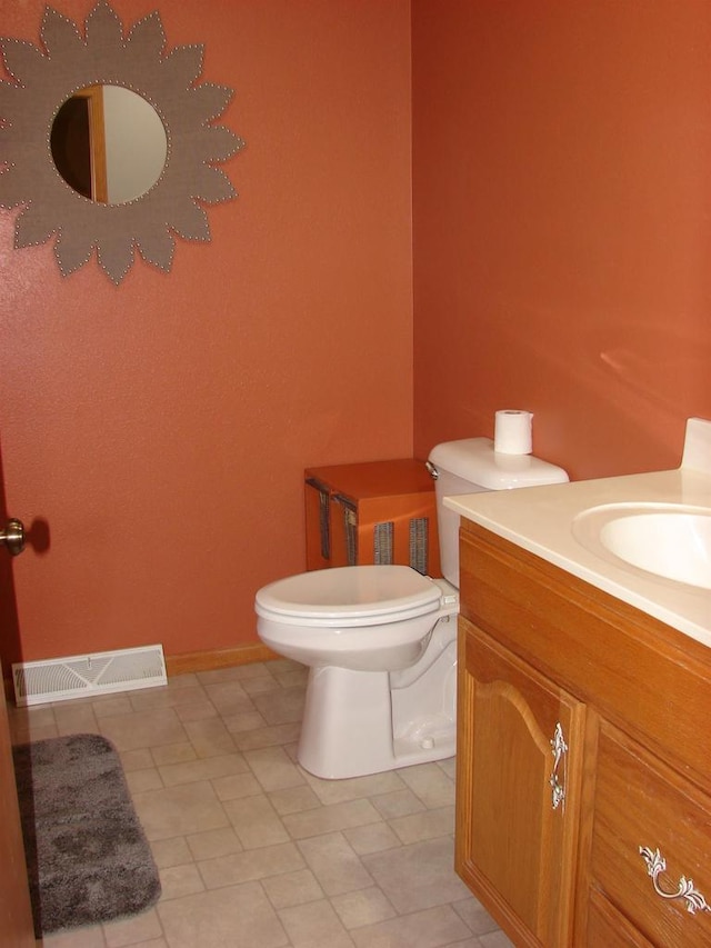 bathroom with baseboards, visible vents, vanity, and toilet