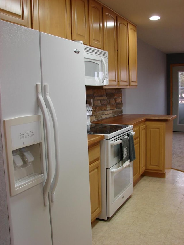 kitchen featuring a peninsula, white appliances, light floors, and recessed lighting