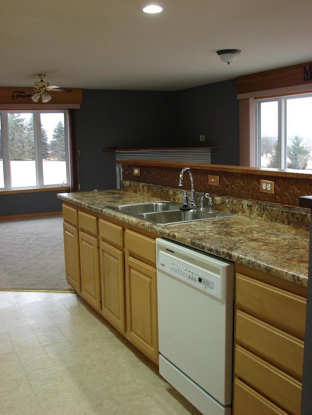 kitchen featuring light floors, a wealth of natural light, dishwasher, and a sink