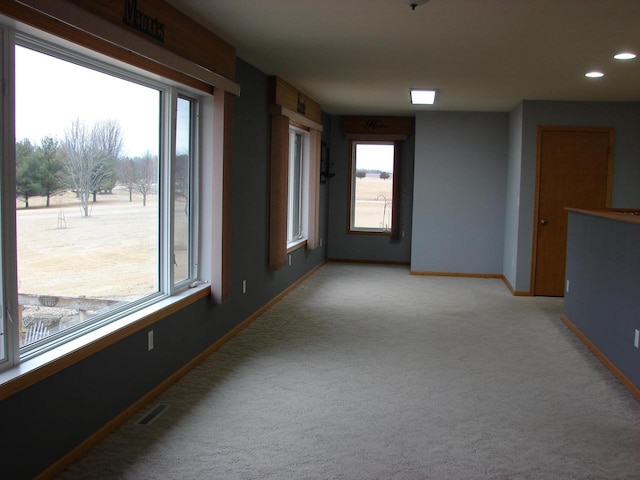 empty room featuring baseboards, recessed lighting, visible vents, and light colored carpet