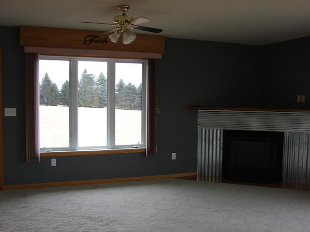 unfurnished living room with a ceiling fan, a fireplace, baseboards, and carpet flooring