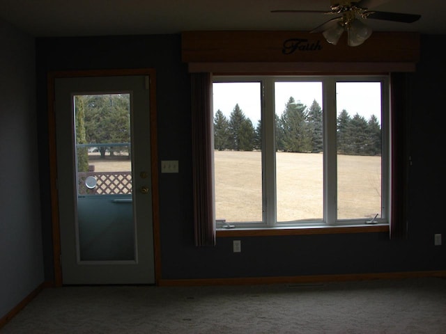 entryway with a ceiling fan, a wealth of natural light, and carpet flooring