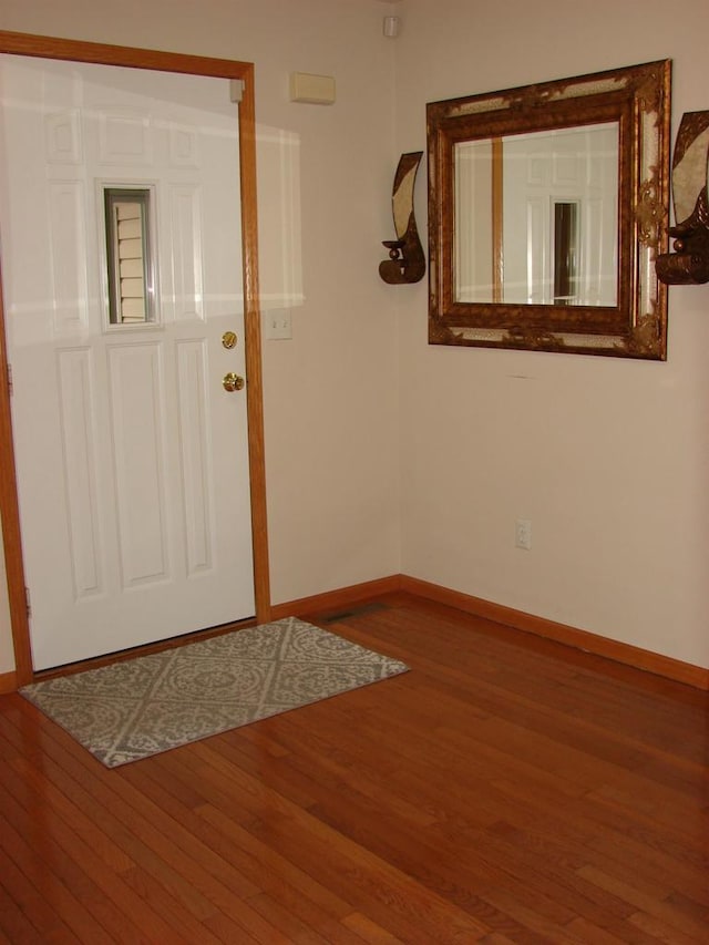 foyer entrance featuring baseboards and wood finished floors