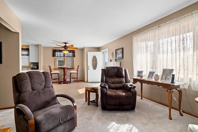 living area with ceiling fan and baseboards