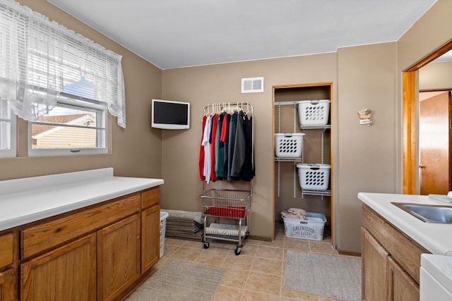 bathroom featuring visible vents, a sink, and tile patterned floors