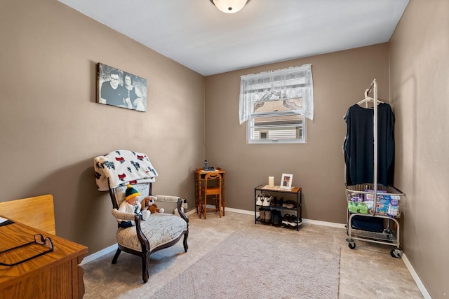 living area featuring carpet flooring and baseboards