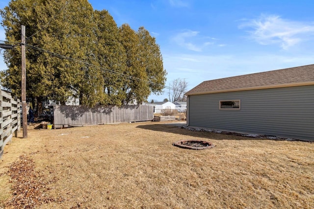 view of yard with an outdoor fire pit and fence