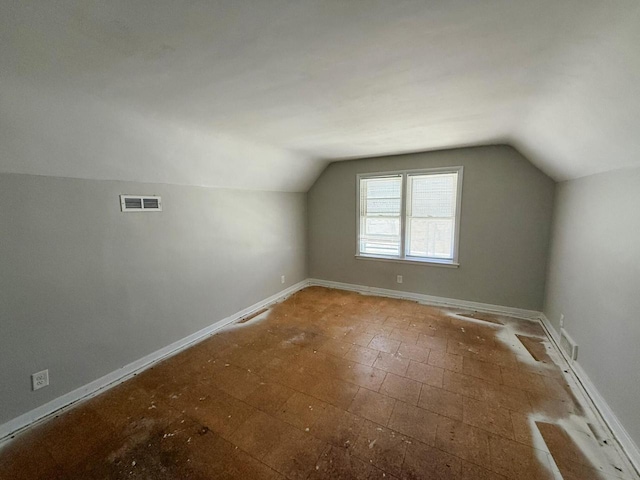 bonus room with vaulted ceiling, visible vents, and baseboards