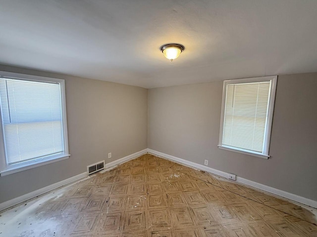 empty room with baseboards and visible vents