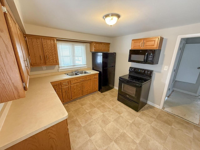 kitchen with black appliances, baseboards, light countertops, and a sink