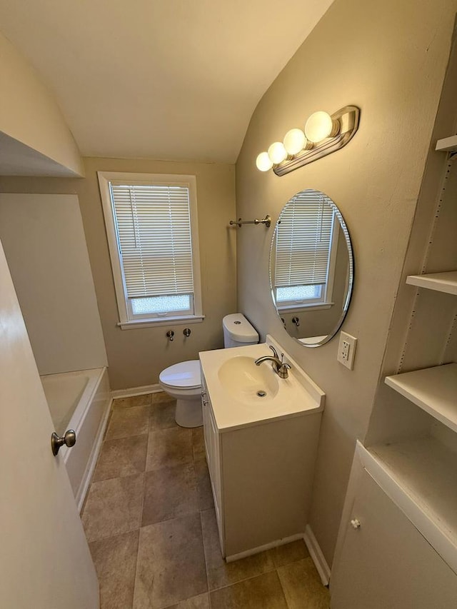 full bathroom with a washtub, toilet, vanity, baseboards, and vaulted ceiling