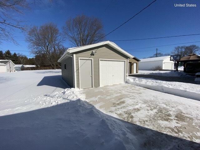 snow covered garage with a detached garage