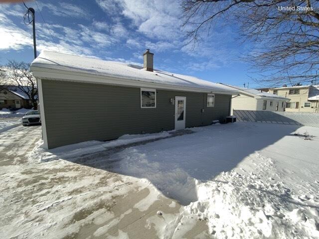 view of snow covered back of property