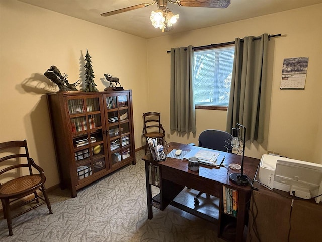 office featuring a ceiling fan, light colored carpet, and baseboards