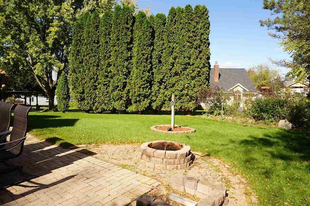 view of yard with an outdoor fire pit and a patio