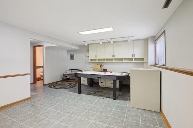 playroom featuring electric panel, track lighting, baseboards, and light tile patterned floors