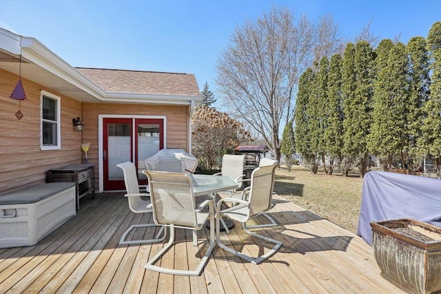 wooden terrace featuring outdoor dining area and a grill