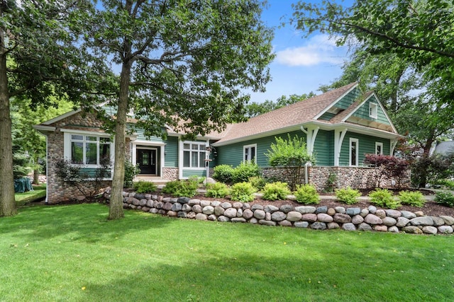 craftsman-style house with stone siding and a front yard