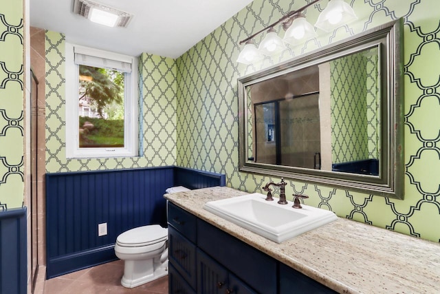 bathroom featuring toilet, wallpapered walls, a shower stall, and visible vents