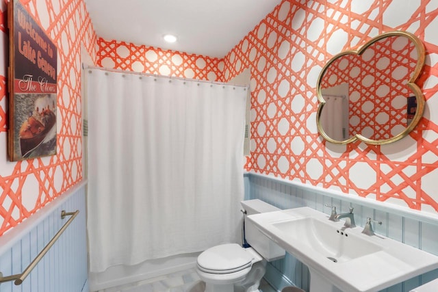 full bathroom with a sink, toilet, and wallpapered walls