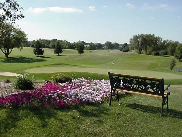 view of home's community featuring view of golf course and a lawn