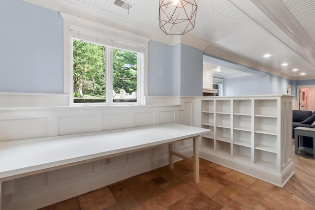 living area featuring a wainscoted wall, a decorative wall, and visible vents