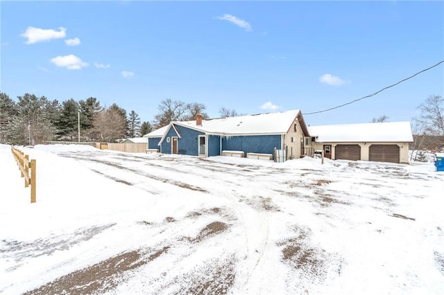 snow covered property with a garage