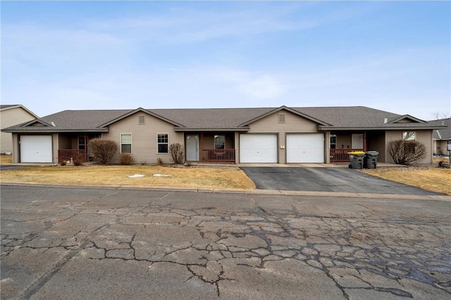 single story home featuring a garage, driveway, and a porch