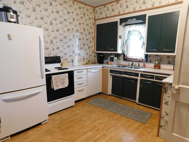 kitchen with light countertops, white appliances, a sink, and wallpapered walls