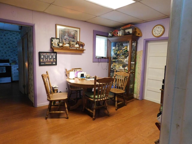 dining area featuring a paneled ceiling and wood finished floors