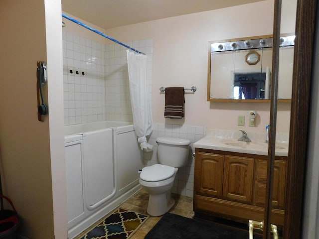 full bath featuring toilet, shower / bath combo, tile walls, and vanity