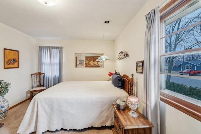 bedroom featuring light colored carpet, visible vents, baseboards, and multiple windows