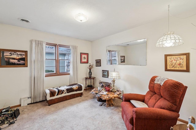 sitting room with carpet floors, a baseboard radiator, and visible vents