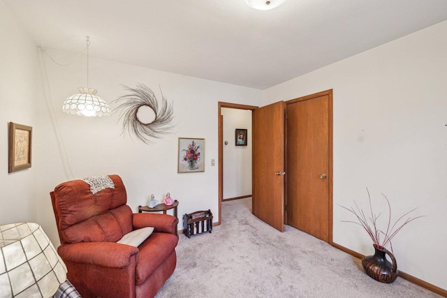 sitting room with baseboards and light colored carpet