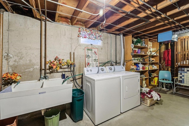 washroom featuring laundry area, separate washer and dryer, and a sink