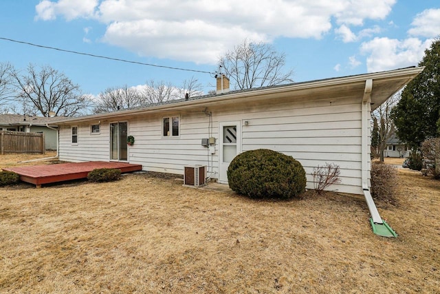 rear view of house with a yard, a chimney, cooling unit, and a wooden deck