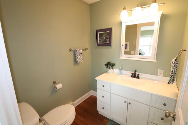 bathroom featuring wood finished floors, vanity, toilet, and baseboards