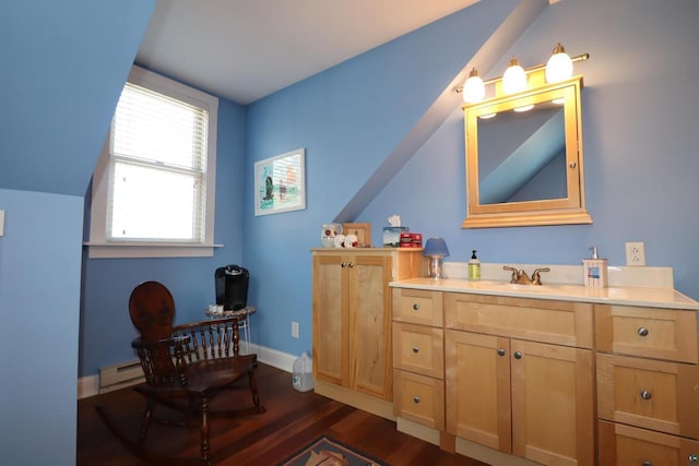 bathroom featuring baseboards, wood finished floors, vaulted ceiling, baseboard heating, and vanity