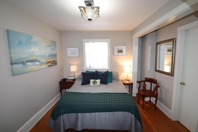 bedroom with baseboards and wood finished floors