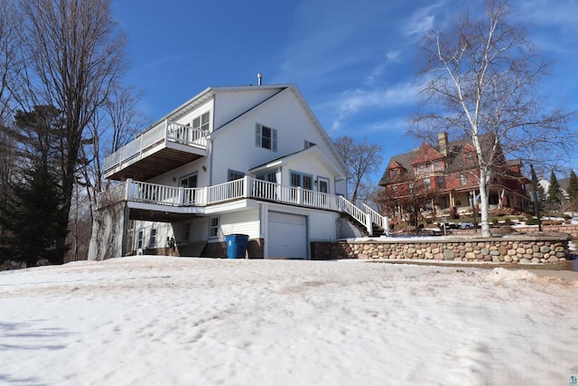 view of snow covered exterior with a balcony and a garage