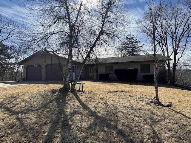 ranch-style house featuring a garage and driveway