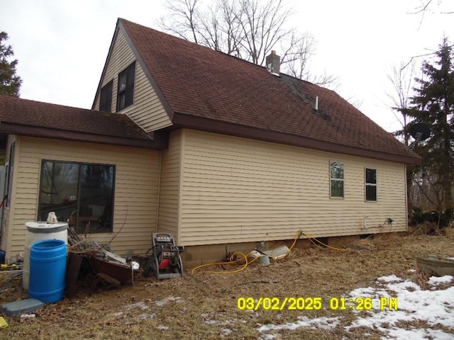 view of property exterior with a shingled roof